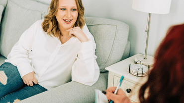 Woman interviewing another woman on a couch